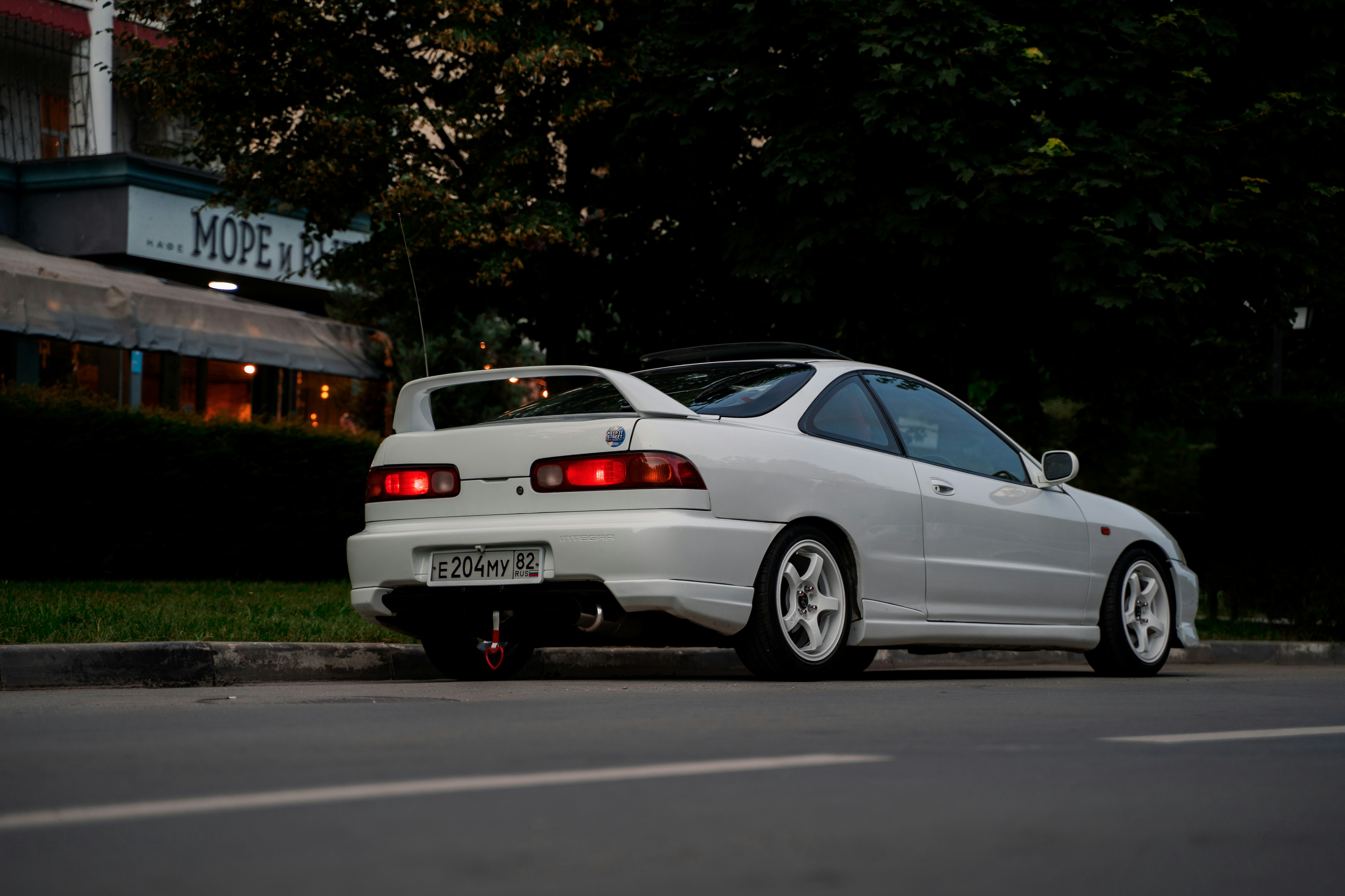 the rear of a white JDM car parked on a street.