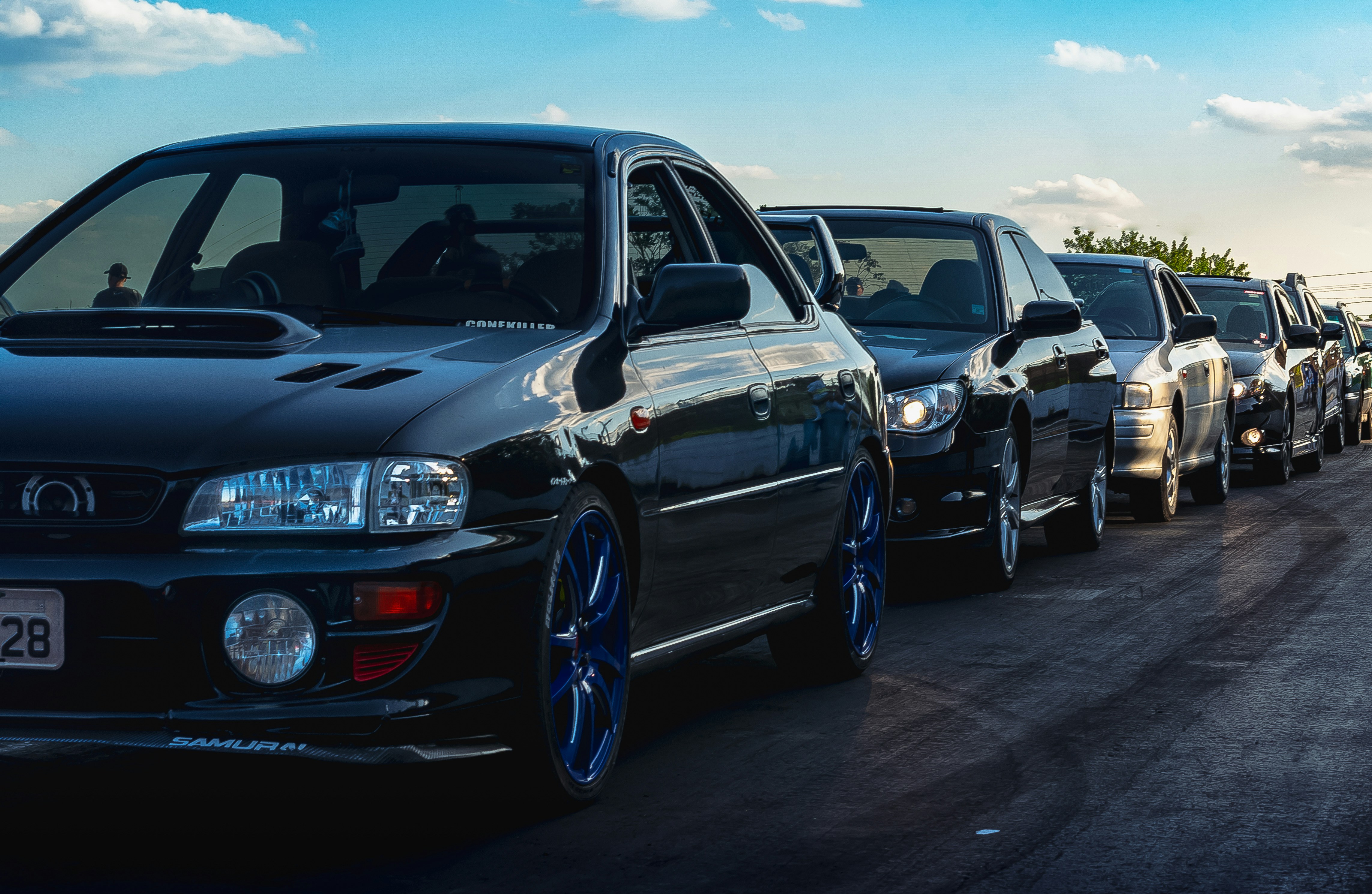 A row of JDM cars on the side of the road.