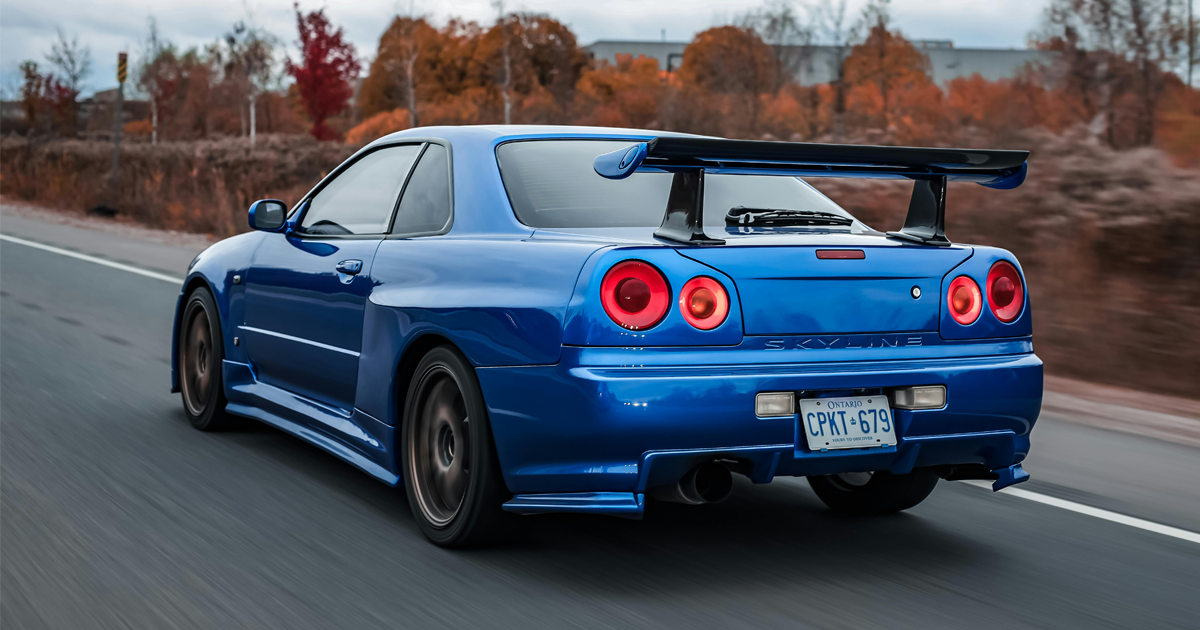 A blue JDM car driving down a street.