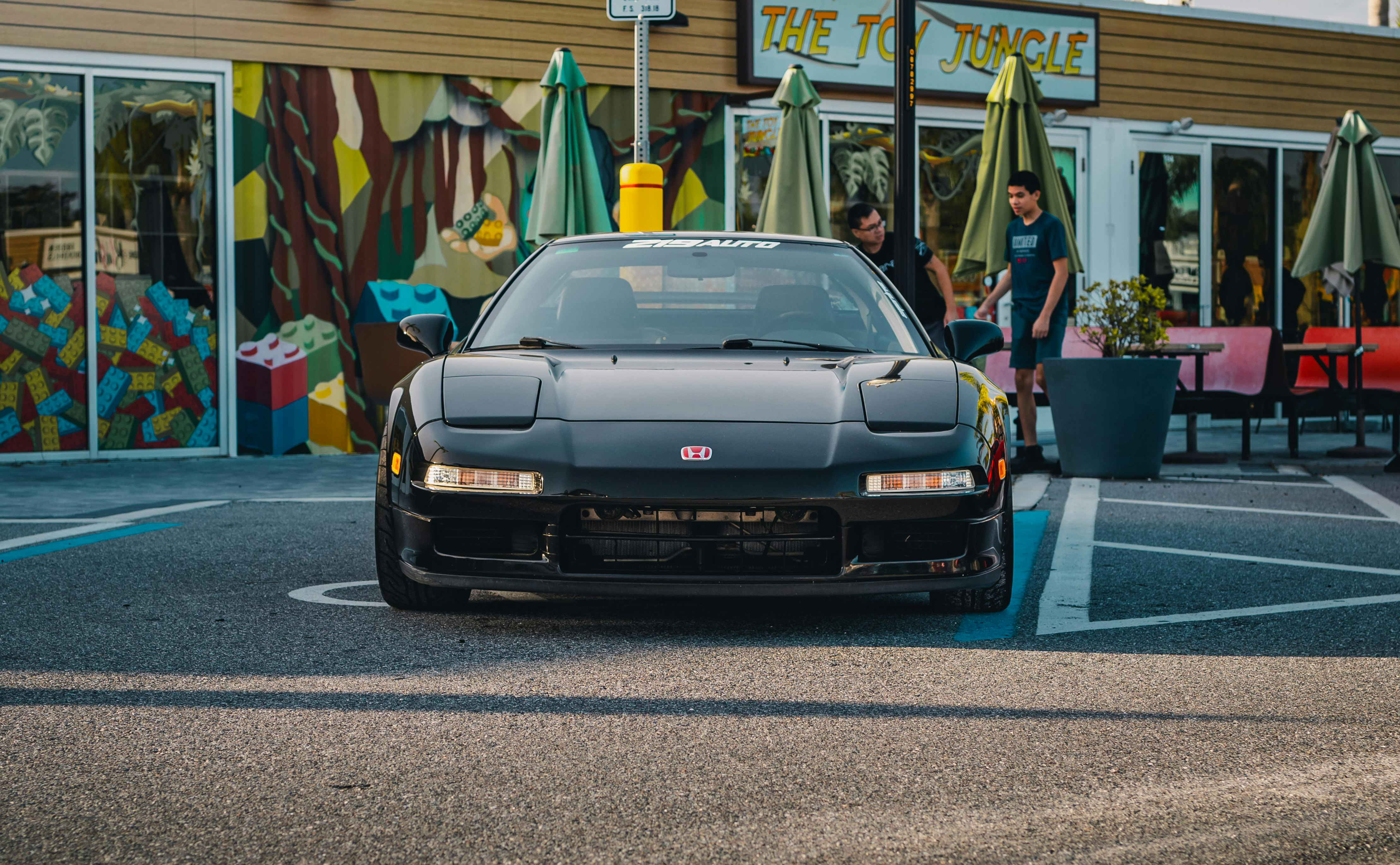 A black Honda jdm car parking in front of a shop.