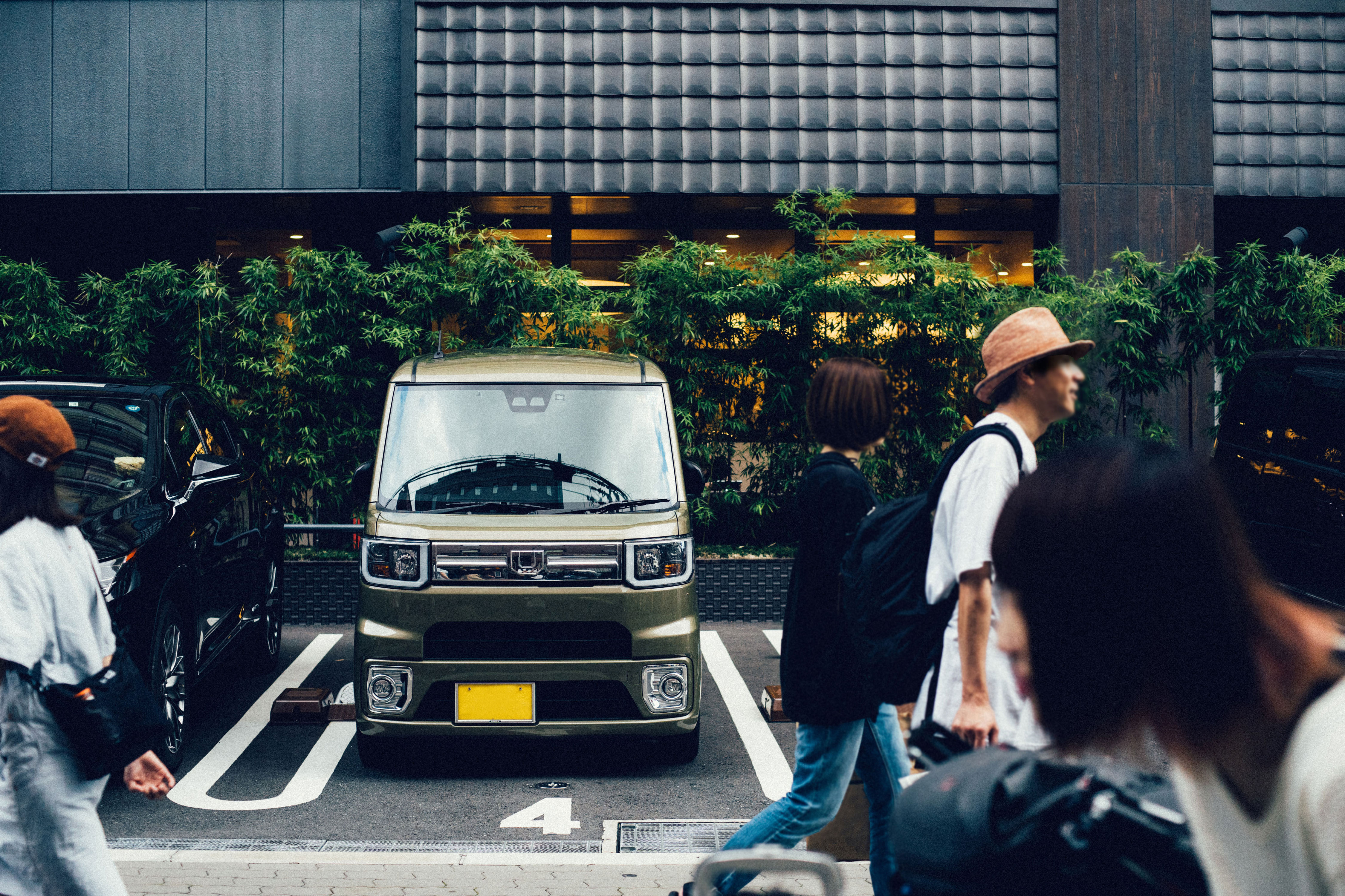 A JDM mini truck parked in a parking lot with people walking past. This car is one of the top JDM cars.