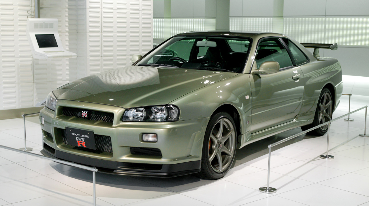 A green Nissan Skyline GT-R in a showroom. This is a JDM car that can be imported into the USA and Quebec in 2025.